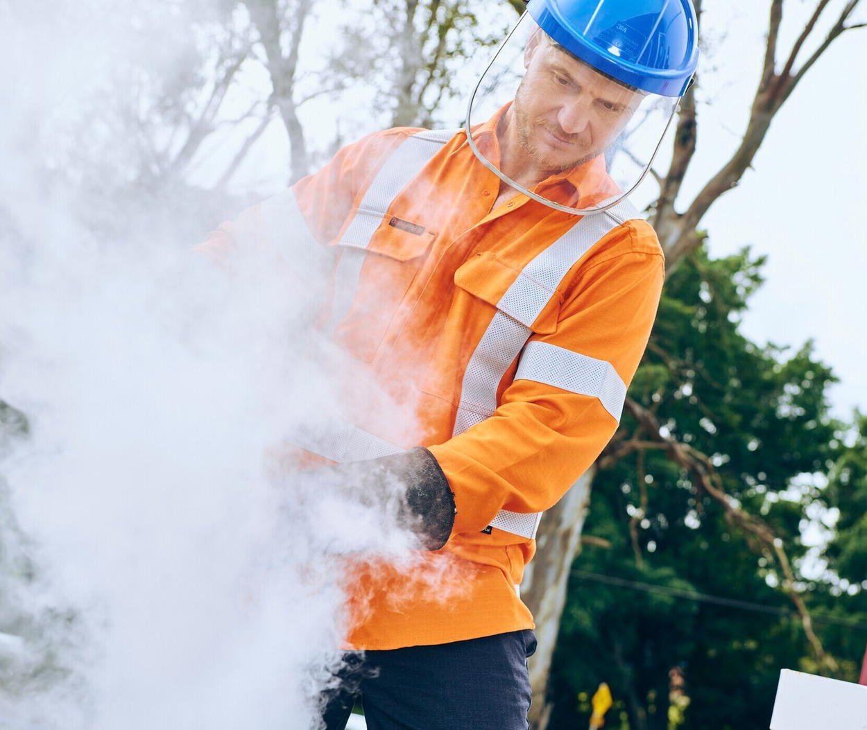 Worker in a Bisley Apex FR shirt and face shield