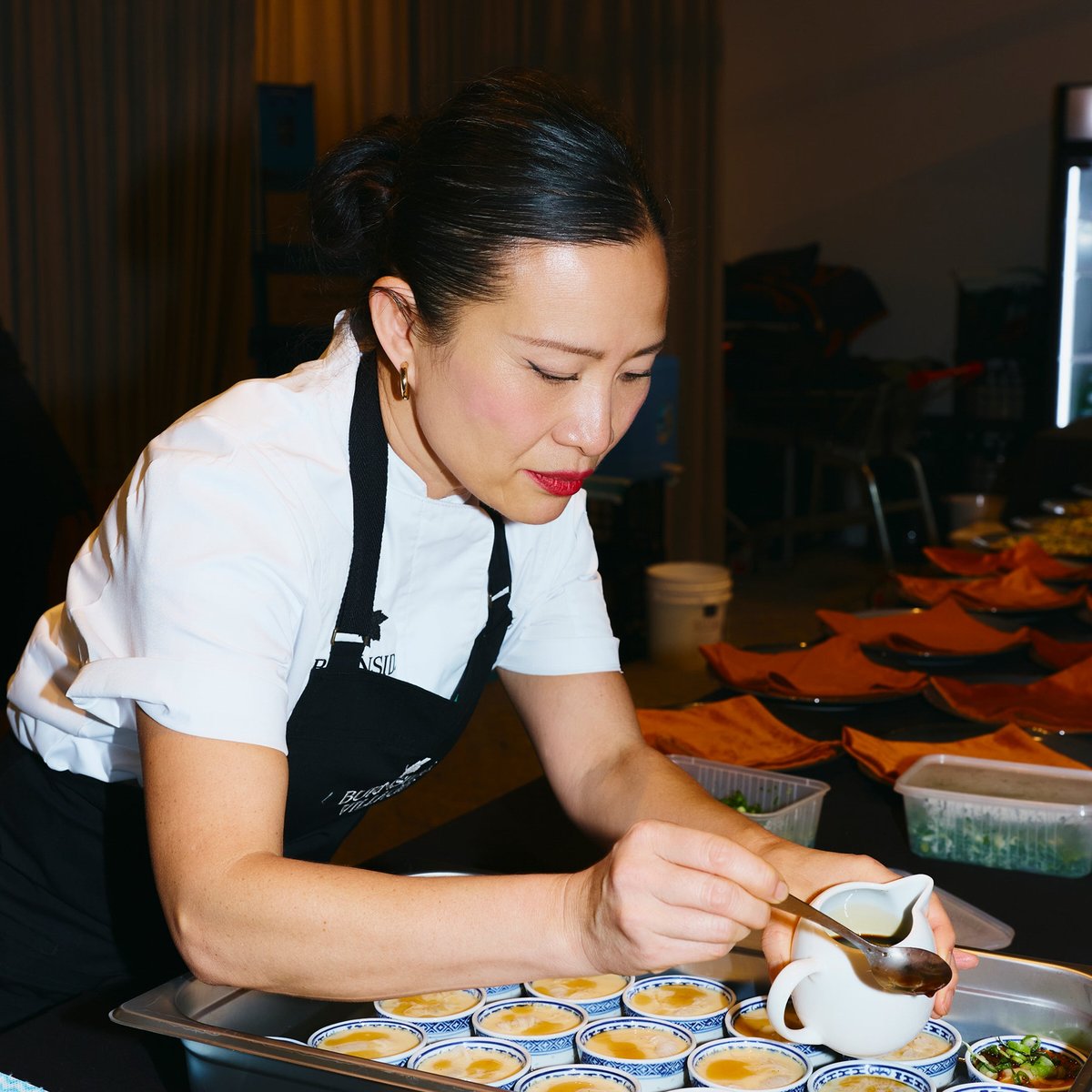 Chef in a Chef Works jacket and apron plating up