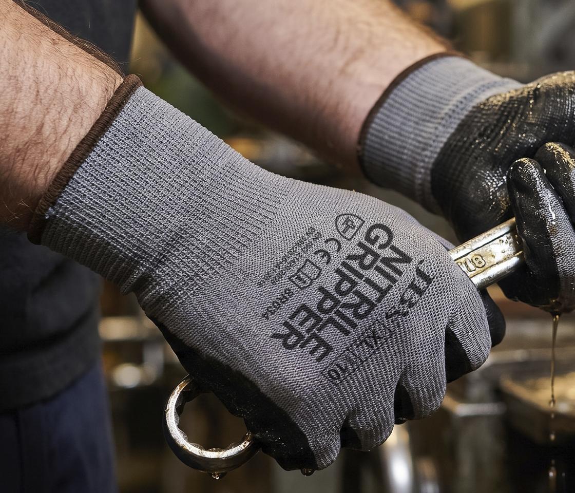 Worker in JB's Wear nitrile grip gloves holding a spanner