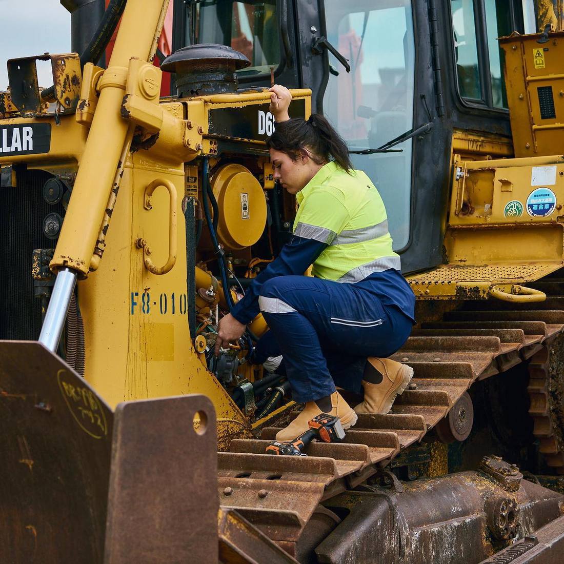 Worker in a Bisley X Airflow hi-vis shirt fixing an excavator